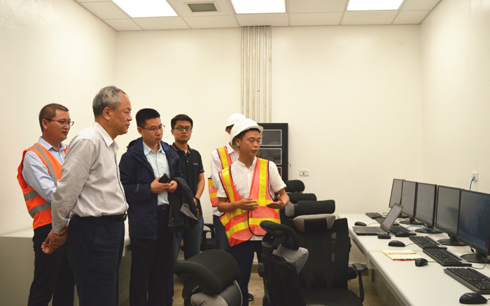 李仰哲（左二）在项目中控室听岳峻经理介绍污水处理工艺流程.jpg